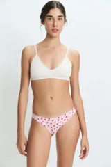Bombacha tipo vedetina de color rosado con estampado de corazones rojos pequeños. Confeccionada en poliamida y elastano con forro de algodón.