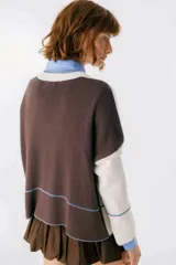 Sweater beige y azul con cuello en V y ribete bordeaux.