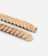 Cinturón mediano con elástico y discos metalizados con texturas aplicadas.