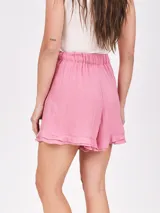 Short holgado color morado, con cintura fruncida y detalle de lazo o nudo en el frente. El ruedo tiene un ligero volante o volado.