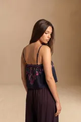 Top de algodón negro con tirantes finos, escote recto y estampado estilo paisley en tonos fucsia, turquesa y verde.