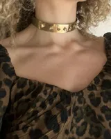 Gargantilla rígida dorada con piezas irregulares de bronce soldadas.