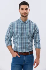 Camisa de manga larga de calce slim, con diseño a cuadros en tonos azul oscuro, verde y blanco. Presenta cuello camisero con botones y bolsillo ojal en el pecho con detalle bordado.