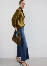 Jeans de denim azul de corte wide leg, tiro medio y diseño clásico con bolsillos y cierre frontal.