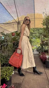 Cartera mochila de diseño versátil, color rosado, confeccionada en material sintético impermeable. Cuenta con doble asa superior, correas ajustables para usar como mochila, compartimento principal con cierre y bolsillo frontal con cierre decorado con tirador largo.