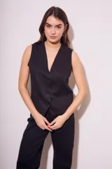 Chaleco de corte sastre con escote en V y cierre frontal de botones. Presenta un diseño sin mangas, entallado al cuerpo, confeccionado en una mezcla de lino y viscosa.