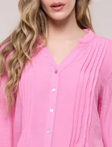 Blusa de silueta suelta color azul, con escote en V y cuello mao. Cuenta con abotonadura frontal, alforzas verticales en el pecho y mangas tres cuartos con puños elastizados.