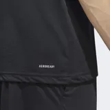 Remera de entrenamiento Adidas, color negro, con cuello redondo y manga corta. Presenta el logo Badge of Sport de Adidas en grande en el frente, compuesto por tres barras blancas en forma ascendente.