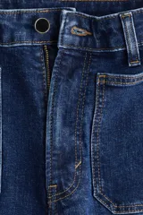 Jean wide leg de tiro alto en denim azul oscuro, con bolsillos delanteros tipo parche y pespuntes en contraste.