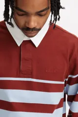 Chomba manga larga a rayas horizontales color ladrillo y celeste, con cuello blanco tipo polo y tapeta con botones.