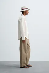 Camisa de algodón color blanco hueso, de corte regular, con cuello abotonado, manga larga terminada en puño con botón y bolsillo de parche en el pecho.