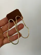 Aros colgantes de bronce dorado con forma irregular.