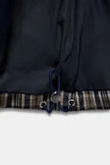 Anorak acolchado de cuello subido y manga larga con puños elásticos ajustables. Presenta un diseño de cuadros, cierre frontal con cremallera, bolsillos laterales con cierre y bajo ajustable con cordones elásticos.