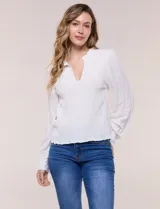 Blusa blanca de silueta semi entallada y tela liviana, con escote en V pronunciado, cuello mao fruncido, pechera con textura elástica en punto smock y mangas largas fluidas con puños abotonados.