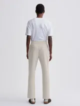 Pantalón de vestir color beige, de corte recto, con pinzas delanteras y cintura elástica lateral.