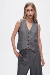 Chaleco gris sin mangas con cuello en V y cierre frontal con botones.