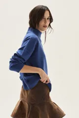 Polera de tejido de punto color azul, con cuello alto, manga larga y puños acanalados.