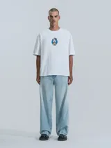 Remera blanca de manga corta con cuello redondo y calce oversize. Presenta un estampado frontal de Mickey Mouse vestido de chef.