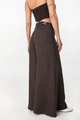 Pantalón de lino marrón oscuro, tiro alto, de corte ancho y estilo palazzo con bolsillos traseros y etiqueta de la marca en la pretina.
