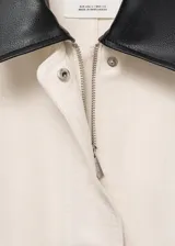 Chaqueta recta de algodón estilo vaquero, color blanco, con manga larga, cuello camisero de efecto piel en contraste, cierre oculto de cremallera y botones, y dos bolsillos delanteros de parche con solapa.