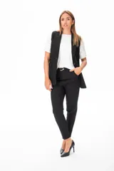 Chaleco negro sin mangas con solapas y cierre con un botón.