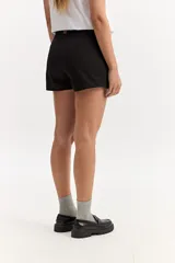 Short pollera sastrero con frente cruzado asimétrico y líneas limpias, confeccionado en algodón.