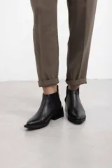 Botineta de cuero negro con textura sutil, con elásticos laterales y taco cuadrado bajo.