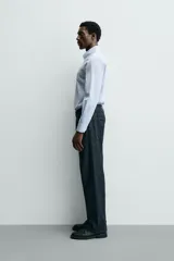 Camisa de corte slim fit confeccionada en tejido de algodón, color celeste. Cuenta con cuello abotonado, manga larga con puños ajustables mediante botón y cierre frontal con botonadura.