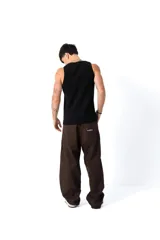 Pantalón de gabardina color marrón oscuro, corte ancho y holgado, con bordado en el frente y la espalda.