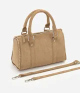 Cartera satchel de gamuza sintética color marrón, con diseño estructurado, doble asa de mano y tachas decorativas en los bordes. Cuenta con cierre superior y herrajes plateados.
