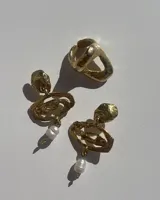 Aros colgantes de bronce dorado con diseño orgánico y perla de río natural en el extremo inferior.