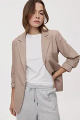 Blazer sastrero negro de calce relajado, con solapa clásica, cierre de un botón frontal y bolsillos con tapa en los laterales.