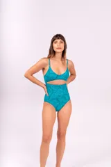 Malla enteriza turquesa con estampado de hojas y abertura en el abdomen.