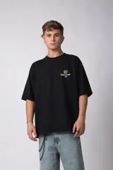 Remera de algodón premium de alto gramaje, corte oversize, color negro. Presenta un pequeño estampado frontal con un oso y el texto 'Richer & Louder VCP'.