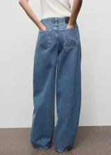 Pantalón de jean estilo balloon, de tiro medio y corte holgado, con diseño de cinco bolsillos, cierre de botón y cremallera.
