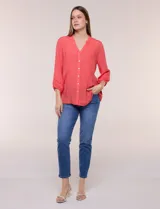 Blusa celeste de silueta suelta y textura liviana, con escote en V, cuello mao y cierre frontal de botones. Cuenta con alforzas verticales en el pecho y mangas tres cuartos con puños elastizados y detalle de galón calado.