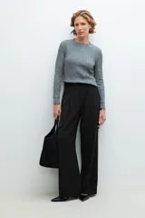 Sweater de punto gris con textura acanalada, cuello redondo con borde festoneado y mangas largas.