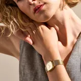 Reloj Skagen modelo Mellen con caja cuadrada dorada y pulsera de malla metálica dorada.