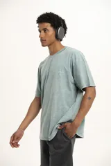 Remera color arena de corte holgado con cuello redondo y manga corta. Presenta un pequeño estampado en el frente.