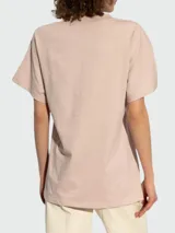 Remera de algodón color rosa pálido, con cuello redondo y mangas cortas. Presenta el logo de la marca bordado en el frente con un diseño de tipografía cursiva en hilo dorado.