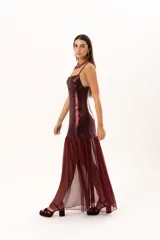 Vestido corto de tirantes finos en color bordó con acabado metalizado brillante. Presenta un corte recto ajustado al cuerpo y un detalle de volado en el ruedo confeccionado en tela traslúcida.