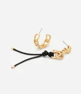 Par de aros colgantes asimétricos de metal dorado con diseño moderno. Un aro presenta una argolla orgánica texturizada y el otro combina eslabones de cadena con un cordón doble negro con punteras metálicas.