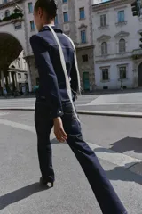 Camisa de denim color azul oscuro, de manga larga y corte entallado. Presenta cuello solapa, un bolsillo de plastrón en el pecho y cierre frontal con botones dorados.