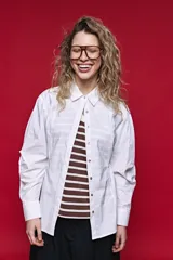 Camisa blanca de manga larga con volumen y estructura, cierre frontal con botones y lazo ajustable en la cintura que realza la silueta.