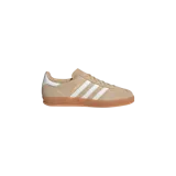 Championes Adidas Gazelle Indoor de gamuza en color beige, con las icónicas tres tiras blancas en los laterales, detalle en el talón de color blanco y suela translúcida de goma caramelo.