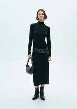 Vestido midi de punto fino con cuello alto, manga larga y diseño recto. Presenta una abertura lateral en el bajo.
