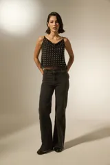 Musculosa negra de poliéster con cuello buche, breteles finos y apliques de tachas metálicas en toda la parte frontal.