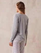 Remera de pijama gris de algodón, con escote redondo, bolsillo en el pecho y mangas largas.