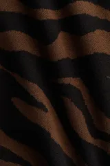 Vestido corto de punto jacquard suave, con estampado de cebra en tonos marrón y negro. Presenta un corte ajustado al cuerpo y mangas largas.