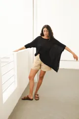 Poncho asimétrico negro de lino, con cuello a la base y mangas 3/4.